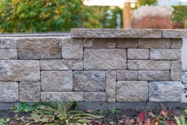 Stacked stone retaining wall in a landscaped yard